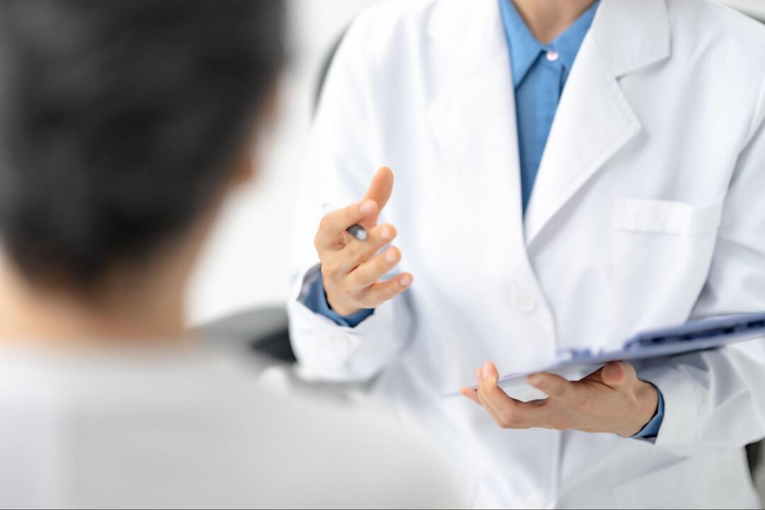 白衣を着た医師が、患者に説明している様子